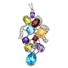 This cheerful pendant is a grape cluster motif, set with multiple shaped and sized semi precious stones, including London blue color blue topaz (app. 1.59 TCW), purple amethysts (app. 0.61 TCW), chartreuse green color peridot (app. 0.62 TCW), golden yellow citrine (app. 0.40 CTS) and burgundy garnets (app. 0.56 TCW). The gemstone "grapes" are accented by round diamond set "leaves", approximately 0.04 TCW. The pendant is topped with a solid style bale. Marks: 750 Dimensions: 1 1/2" long including bale x 11/16" wide Luxury Round Multi-stone Jewelry, Elegant Multicolor Pendant Gemstones, Elegant Multicolor Gemstone Pendant, Multicolor Gemstone Pendant With Accents, Multi-stone Pendant Gemstones For Jewelry Making, Diamond Necklace Indian, Art Deco Pendant Necklace, Round Diamond Setting, Chartreuse Green