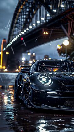 a black sports car parked in front of a bridge at night with lights on it