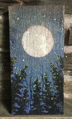 a painting on wood with trees and the moon