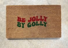 a door mat with the words be jolly by golly written in red and green