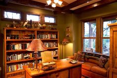 a living room filled with lots of furniture and bookshelves next to a window