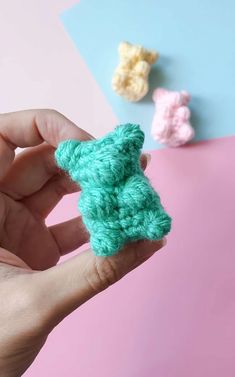 someone is holding a tiny crocheted teddy bear