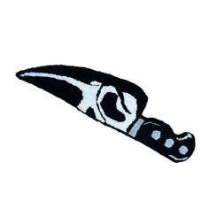 a black and white knife with a skull on it's head is laying down