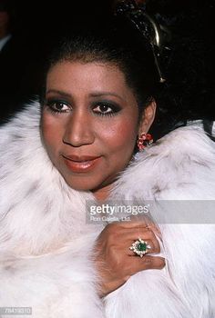 a woman in a fur coat and ring on her left hand, posing for the camera