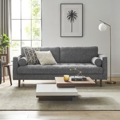 a living room with a couch, coffee table and two lamps on the side tables