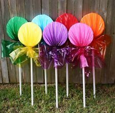 a group of colorful lollipops sitting on top of each other in front of a wooden fence