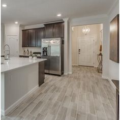 a kitchen with wood flooring and stainless steel appliances