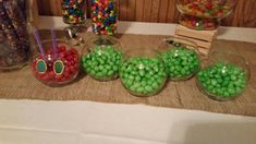 there are many different types of candies in glass bowls on the table with straws