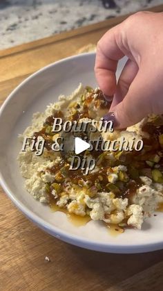 a person is dipping some food into a white bowl on a wooden table with the words bourbon fig & strudato dip