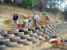 people are working on the construction of a wall made out of old tires