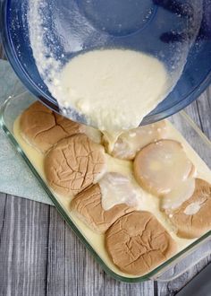 the batter is being poured on top of the hot dog buns in a glass dish