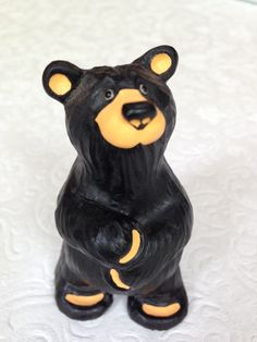 a black and yellow bear figurine sitting on top of a white tablecloth