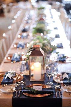 a long table set with place settings, candles and napkins for dinner guests to enjoy