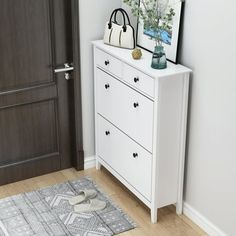 a white dresser sitting next to a wooden door