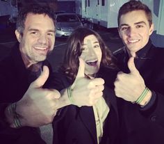 two men and a woman giving the thumbs up sign in front of an rv park