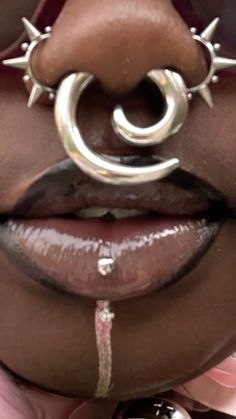 a close up of a person's lips with metal decorations on their lip and nose ring