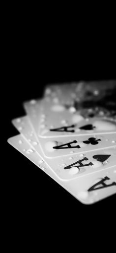 four playing cards with chinese writing on them in black and white photo taken from above