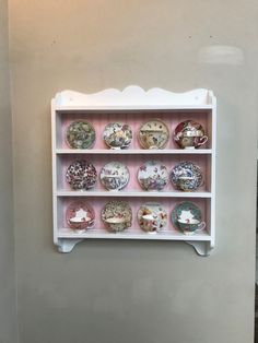 a white shelf filled with lots of different types of plates on top of each other