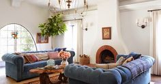 a living room with blue couches and rugs on the floor in front of a fireplace