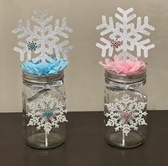 two mason jars with snowflakes in them