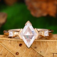 a diamond ring sitting on top of a leaf