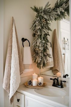 a bathroom sink with candles and towels on it