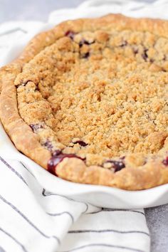 a blueberry pie sitting on top of a white plate