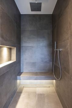 a walk in shower sitting inside of a bathroom next to a wall mounted faucet