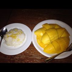 two white plates topped with sliced mangoes next to a bowl of yogurt