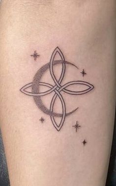 a woman's thigh with a tattoo design on the side of her leg, and stars in the background