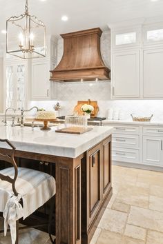 a large kitchen with an island in the middle and two chairs at the counter top