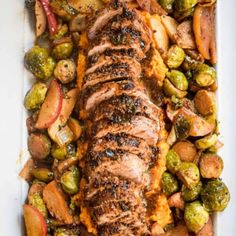 pork roast with brussel sprouts and potatoes on a white platter