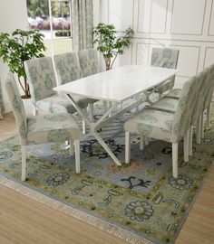 a dining room table and chairs with a rug on the floor