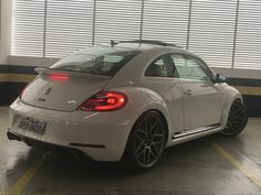 a white volkswagen beetle parked in a garage