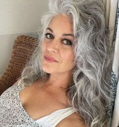 a woman with grey hair sitting in a chair