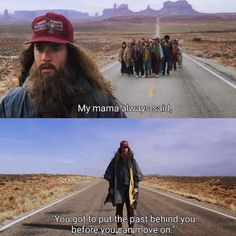 a man with long hair and beard walking down the road next to another man wearing a red hat