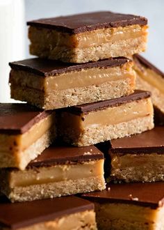 several pieces of chocolate and peanut butter bars stacked on top of each other