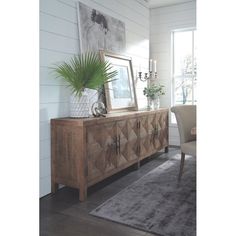 a living room with a rug, table and chair in it next to a window