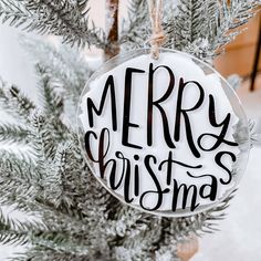 a merry christmas ornament hanging from a tree