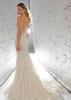 a woman in a wedding dress is standing against a wall and posing for the camera