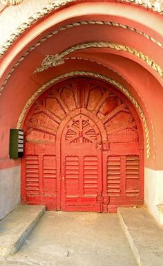 a red door with two steps leading up to it