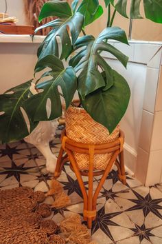 a potted plant sitting on top of a wooden stool next to a bath tub