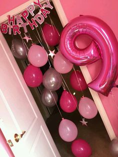 pink and silver balloons are hanging from the ceiling in front of a door with an instagram sign that says happy birthday