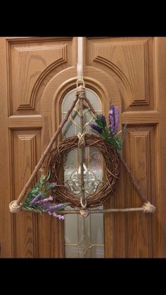 a harry potter house wreath hanging on the front door with purple flowers and lavenders