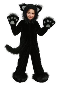 a little boy in a cat costume standing with his hands up and smiling at the camera