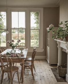 a dining room table and chairs in front of a fireplace