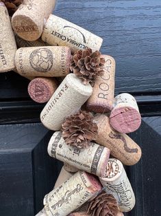 a bunch of wine corks are stacked on top of each other with pine cones