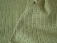 a close up view of a green bedspread that has been made into a blanket