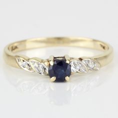 a yellow gold ring with a blue sapphire and white diamonds