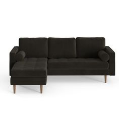 a black couch with a footstool sitting next to it on a white background